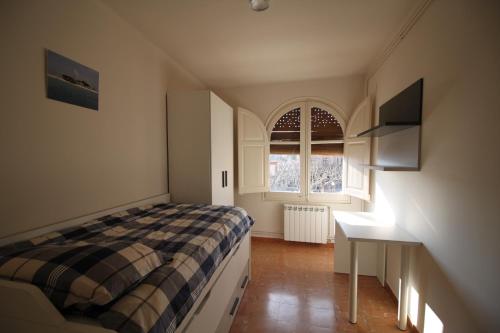 a bedroom with a bed and a desk and a window at Apartment Market Square in Cardona