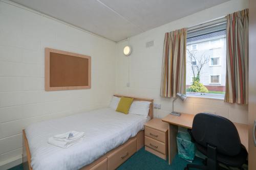 a bedroom with a bed and a desk and a window at Castlewhite - UCC Summer Beds in Cork