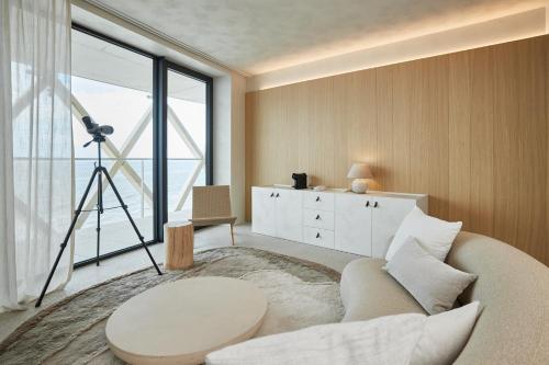 a living room with a white couch and a large window at C-Hotels Silt in Middelkerke