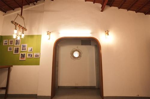 a hallway with a round mirror on a wall at Malama Stay The Nook 2BHK Alibaug in Alibaug