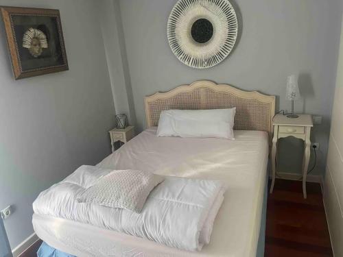 a bedroom with a bed with white sheets and a mirror at Triplex 3 Rooms 2 Baños Terraza in Sabiñánigo