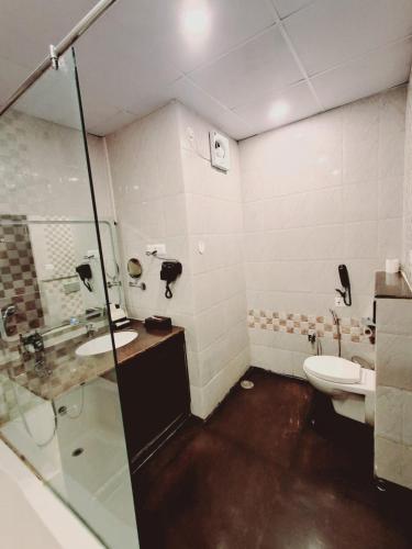 a bathroom with a toilet and a sink and a shower at The Fern Residency, Bodhgaya in Bodh Gaya