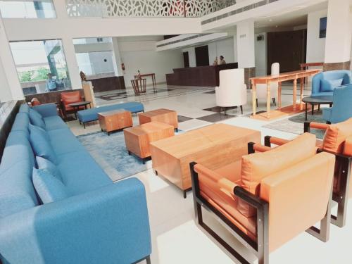 a living room with blue couches and a table at The Fern Residency, Bodhgaya in Bodh Gaya