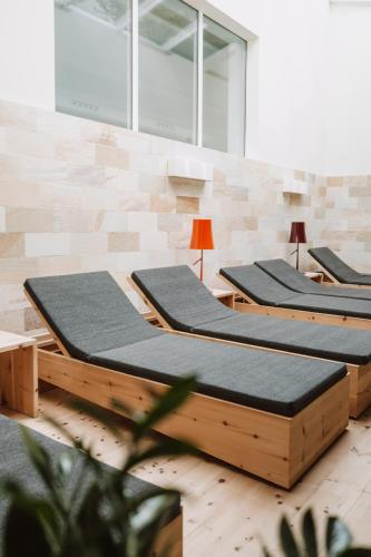 a row of wooden beds in a room at Boutique-Hotel Ballguthof am Golfplatz in Lana