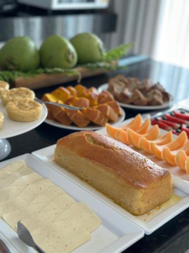 a table with different types of food on plates at Hotel Icaraí Beach in Icaraí