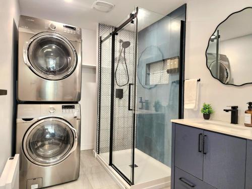 a bathroom with a washing machine and a shower at The Coziest - Hot Tub - EV Chrger & Free Parking in Quebec City