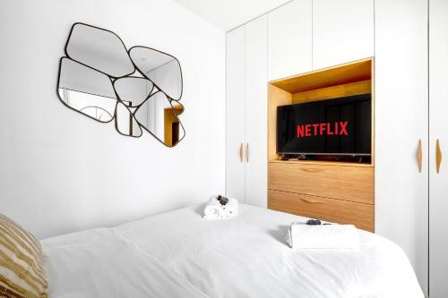 - une chambre avec un lit et une télévision murale dans l'établissement Suite Javel - Appartement à Paris, à Paris