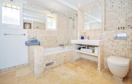 a bathroom with a tub and a toilet and a sink at Villa Mansart in Théoule-sur-Mer