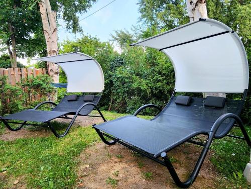 two chairs sitting in the grass in a yard at Luxury Retreat with Hot Tub - EV Chrger & Parking in Quebec City