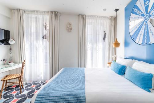 a blue and white bedroom with a large bed at Hotel Joke - Astotel in Paris
