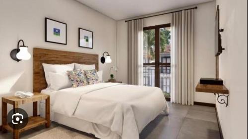 a bedroom with a large white bed and a window at Quinta Santa Bárbara eco resort in Pirenópolis