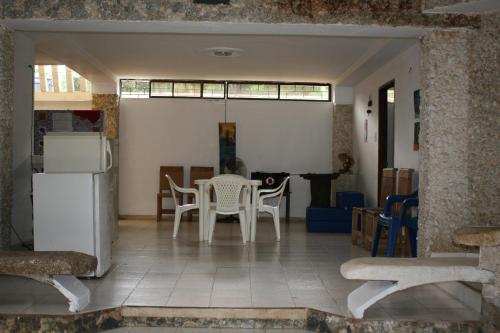 cocina con mesa, sillas y nevera en Vivienda Turística El Castillo, en Buritaca