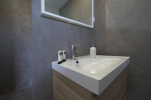 a bathroom with a white sink and a mirror at Le Mazet Chambre d'Hôtes in Mauguio