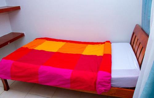 a colorful blanket on a bed in a room at Studio Apartment near the Airport in Nairobi