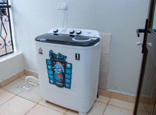 a small refrigerator in a corner of a room at Studio Apartment near the Airport in Nairobi