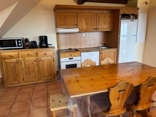une cuisine avec une table en bois et un réfrigérateur dans l'établissement Duplex Pra roustan, à Uvernet