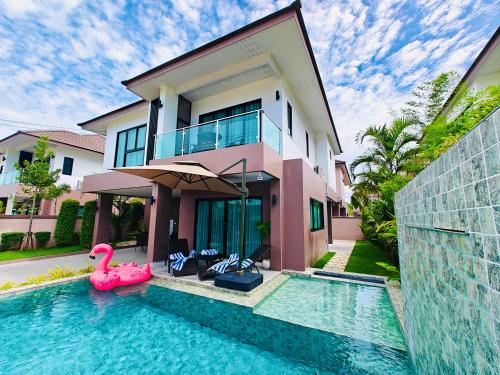 a house with a swimming pool in front of a house at 超值优选 新房特惠 独栋泳池花园别墅 15分钟到海边 in Ban Huai Yai