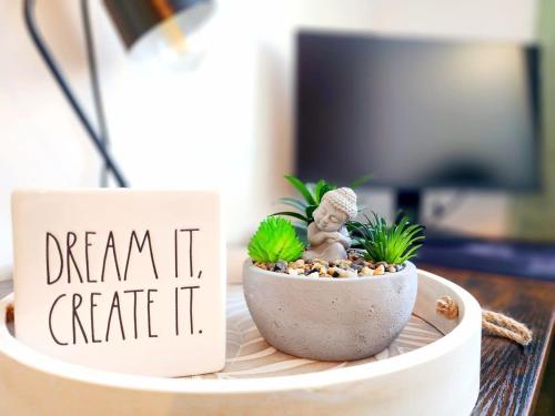 a small plant in a pot on a table with a sign at Enchanting Loft - Fireplace AC Quebec Downtown in Quebec City