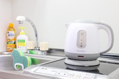 a white mixer sitting on a counter in a sink at ハイクレスト中野203 in Tokyo
