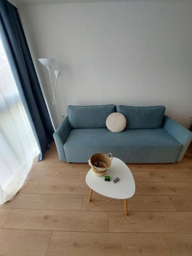 a living room with a blue couch and a table at Sky Hills 2 Apartment in Sandanski