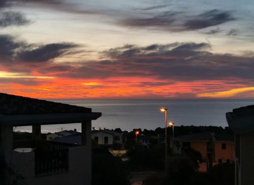 a sunset over a city with a street light at Casa Mare e Sole IUN R2610 in Cala Gonone