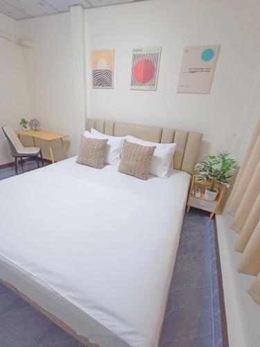 a white bed with two pillows on it in a room at D72 Family House, 8PAX 3BR Hat Yai Middle Town in Hat Yai