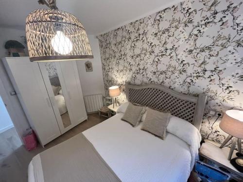 a bedroom with a bed and a wall with flowers at El Capricho de Rosa in Puerto de Béjar