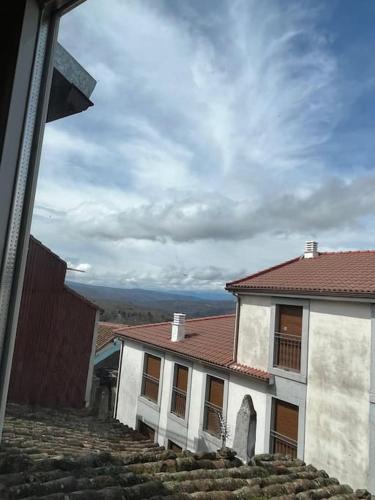 a white house with a red roof on a hill at El Capricho de Rosa in Puerto de Béjar
