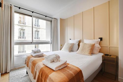 une chambre avec un grand lit avec des serviettes dessus dans l'établissement Pick A Flat's Apartments in Tour Eiffel - Rue de l'Amiral Hamelin, à Paris