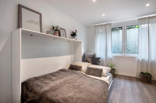 a bedroom with a large bed and windows at Helle Lichtdurchflutete Wohnung in Karsau