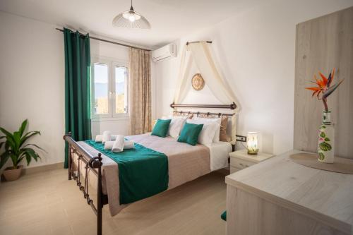 ein Schlafzimmer mit einem großen Bett und einer grünen Decke in der Unterkunft Villa Mazzeto Casa Alonia in Áno Yerakaríon