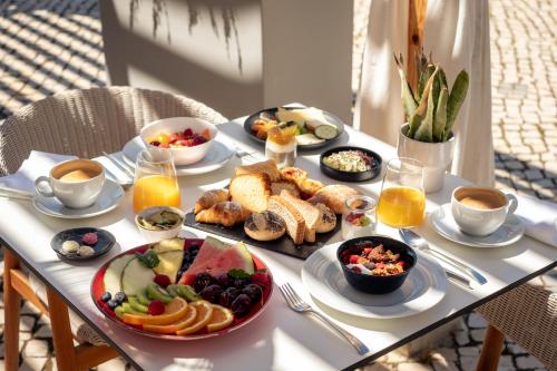 a table with breakfast foods and drinks on it at Vila Valverde Design Country Hotel in Luz