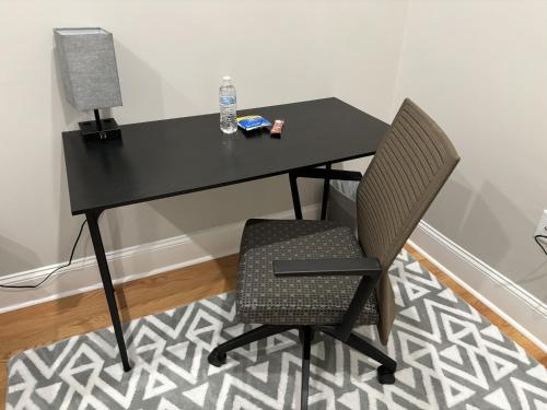 a black desk with two chairs and a lamp at HomeStay - B&B - Near South Boston - JFK-Umass Area in Boston