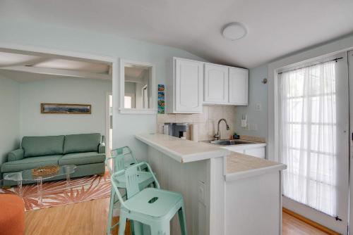 a kitchen with white cabinets and a green couch at New The Cottage at James House in Key West