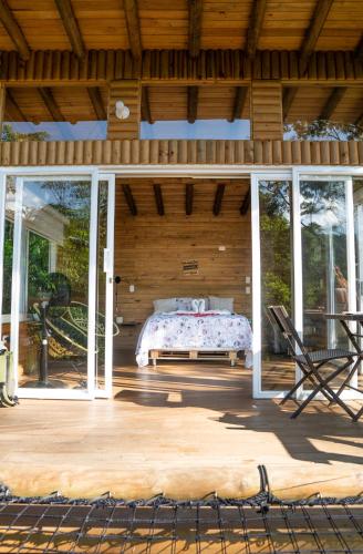 a bedroom in a wooden house with a bed on a patio at La Chagra VIP - Cabaña & Glamping en Villavicencio in Villavicencio