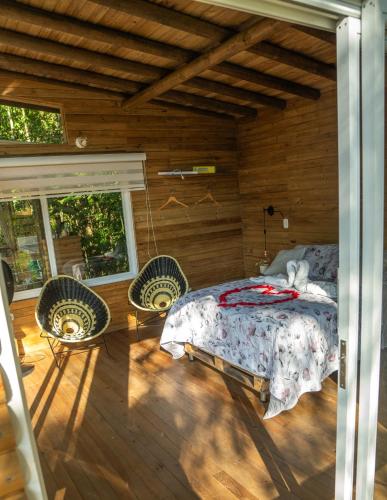 a bedroom with a bed and two chairs and a window at La Chagra VIP - Cabaña & Glamping en Villavicencio in Villavicencio