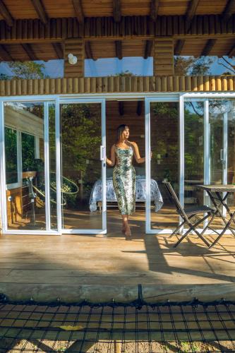 a woman standing on the porch of a house at La Chagra VIP - Cabaña & Glamping en Villavicencio in Villavicencio