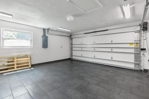 a garage with white doors and a tile floor at Relaxing Coastal Comfort - Heated Pool in Clearwater