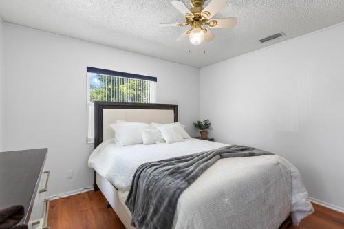a bedroom with a bed with a ceiling fan at Relaxing Coastal Comfort - Heated Pool in Clearwater