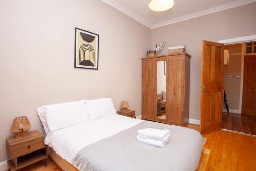 Un dormitorio con una cama blanca con dos toallas encima. en Beautiful 2 Bed Apartment Rose St, en Glasgow