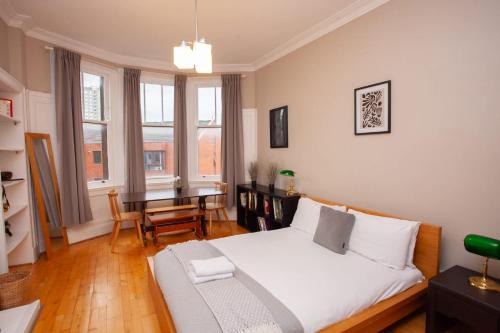 Un dormitorio con una cama y una mesa dentro. en Beautiful 2 Bed Apartment Rose St, en Glasgow
