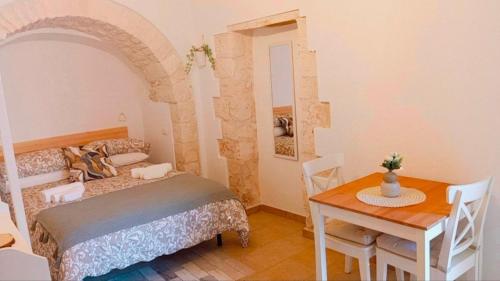 - une chambre avec une table, un lit, une table et des chaises dans l'établissement La Casetta di Francy, à Martina Franca