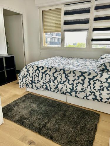 une chambre avec un lit avec une couette bleue et blanche dans l'établissement La belle vie, à Saint-Denis