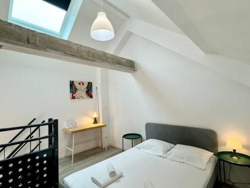 une petite chambre avec un lit et une table dans l'établissement Au Cœur des Moissons, à Reims