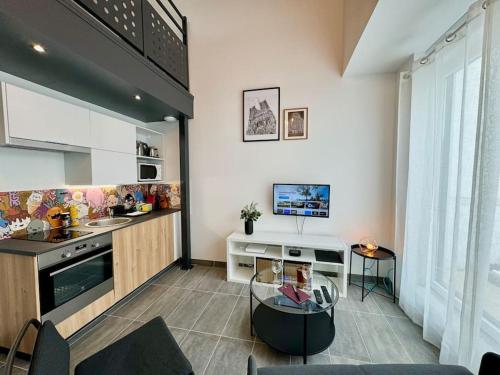 Il comprend une cuisine et un salon avec une table en verre. dans l'établissement Au Cœur des Moissons, à Reims