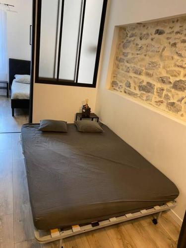 un lit dans une chambre avec un mur en pierre dans l'établissement Ô COEUR de SETE, à Sète