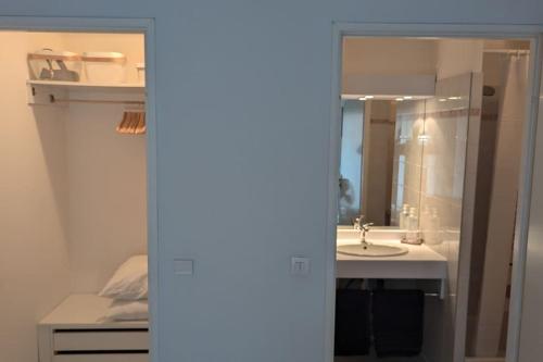 une salle de bain avec un lavabo et un miroir dans l'établissement T2 ouvert à 5 min des plages, au calme, avec balcon et garage, à Menton