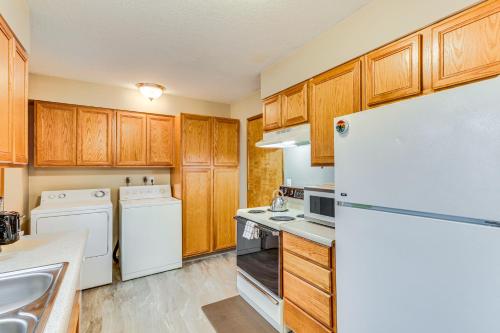 a kitchen with white appliances and wooden cabinets at Pet-Friendly Gem with Ping-Pong Table in Oregon! in Forest Grove