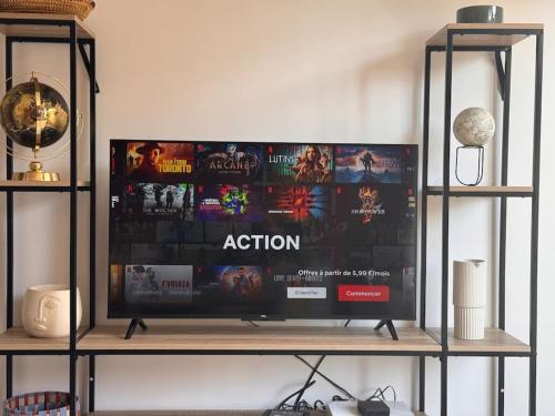 a tv on a shelf with a movie on it at Appart premium à 5 min de l aeroport Orly in Athis-Mons