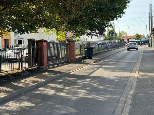 a car driving down a street next to a fence at Appart premium à 5 min de l aeroport Orly in Athis-Mons